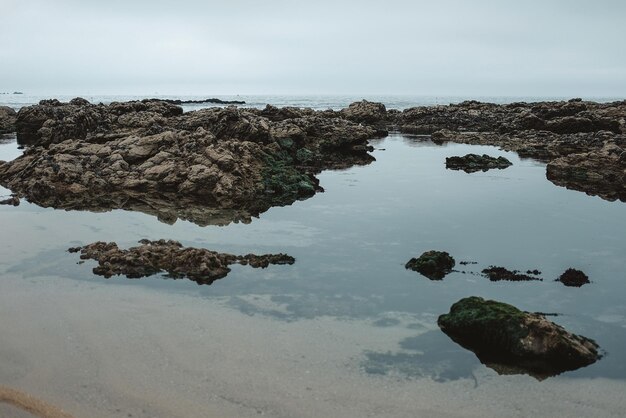 Spokojny ocean otoczony skałami, świetny na tapety.