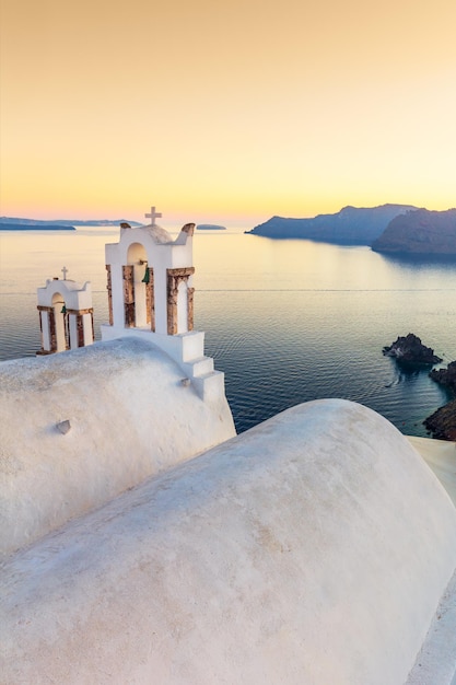 Spokojny wieczór Romantyczny zachód słońca na popularnym kurorcie na wyspie Santorini Łuk z dzwonkiem błękitne morze i romantyczne niebo o zachodzie słońca w Oia na wyspie słońca Santorini Grecja Europa