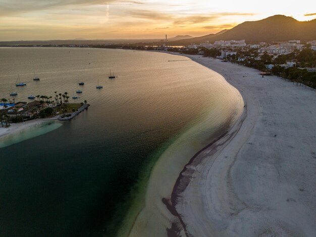 Spokojny zachód słońca na plaży w pobliżu oceanu z górskim tłem Mallorca