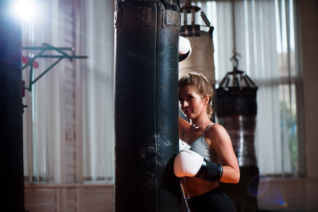 Sport, boks, kobieta na tle siłowni sportu.