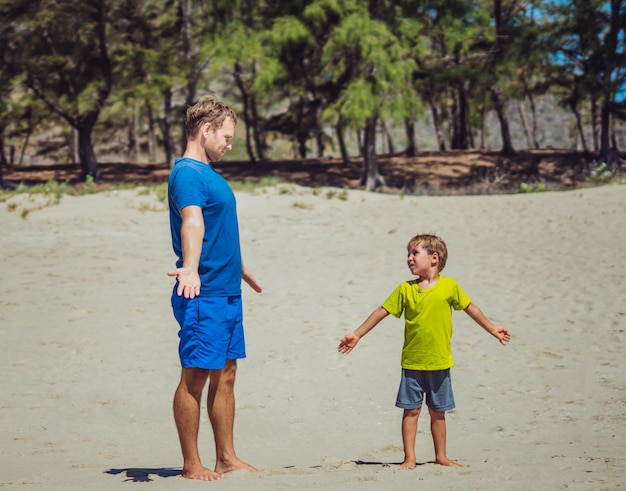 Sport dla małych dzieci Ojciec słodki syn ćwiczący na piaszczystej plaży w pobliżu parku leśnego po treningu ciesząc się razem na świeżym powietrzu ćwiczenia ręki technika tata wpływ na światopogląd chłopca