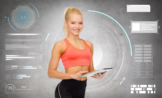 sport, fitness i technologia - szczęśliwa sportowa kobieta z komputerem typu tablet na szarym betonowym tle