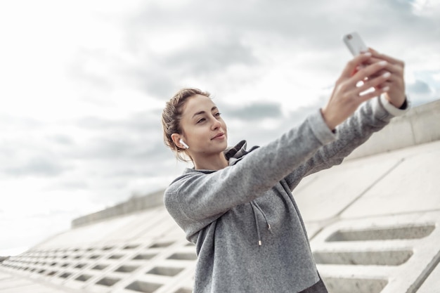 Sport i atrakcyjna kobieta robi selfie na smartfonie na zewnątrz