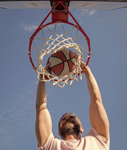 Sport i hobby wsad w koszu wsad w ruchu letnia aktywność sportowy mężczyzna z piłką do koszykówki na korcie zawodowy koszykarz trenujący na zewnątrz facet ma motywację sportową