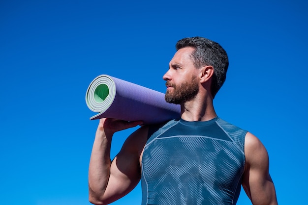 Sport I Zdrowy Tryb życia. Sportowiec Robi Poranne ćwiczenia. Trening Jogi. Sportowiec Z Matą Do Jogi Na świeżym Powietrzu. Opieka Zdrowotna. Muskularny Facet Uprawia Sport. Człowiek W Odzieży Sportowej.