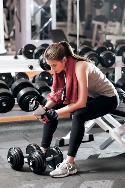 Sportive Kobieta Po Odpoczynku Do Picia Na Siłowni