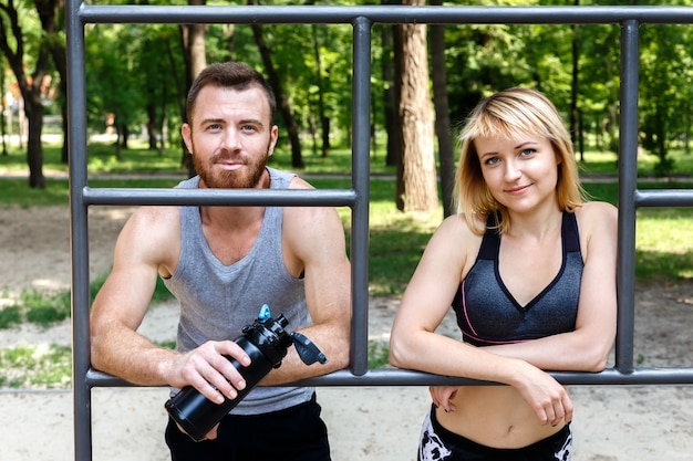 Sportowa Blondynka I Brodaty Mężczyzna Odpoczywa Po Treningu Treningu W Parku Na świeżym Powietrzu.