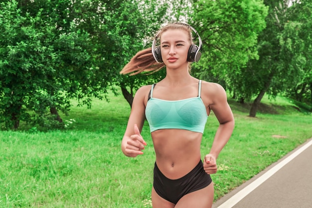 Sportowa dziewczyna biegająca w parku Pojęcie zdrowego stylu życia Sprzęt sportowy Reklama w stylu fitness