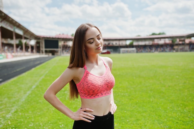 Sportowa dziewczyna fitness w odzieży sportowej na stadionie piłkarskim sporty na świeżym powietrzu Szczęśliwa seksowna kobieta trening na tle zielonej trawy