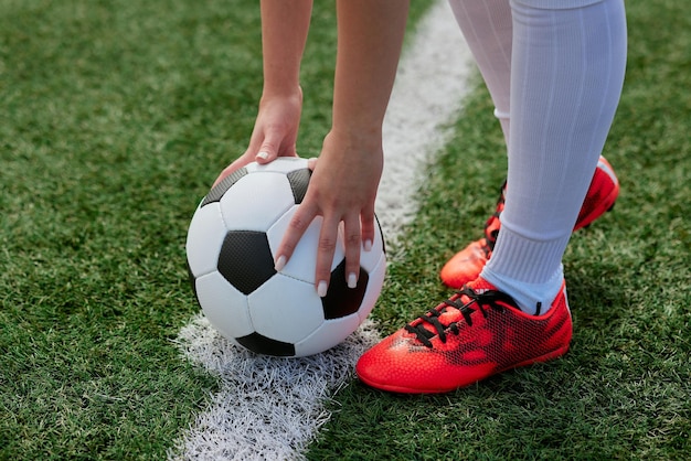 Sportowa dziewczyna piłkarz z piłką nożną na boisku koncepcja profesjonalnej piłki nożnej kobiet