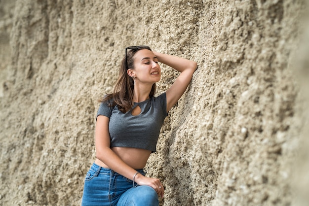 Sportowa dziewczyna w górę i dżinsy pozowanie latem w piaszczystym górskim kamieniołomie. zdrowy tryb życia