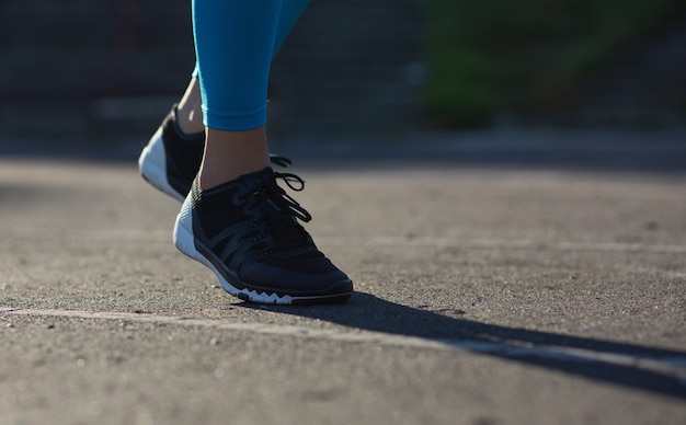 Sportowa kobieta nogi podczas treningu joggingu na stadionie. Pusta przestrzeń