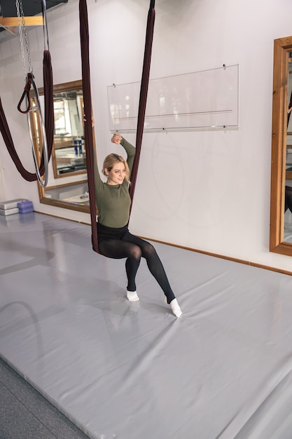 Zdjęcie sportowa kobieta robi ćwiczenia rozciągające w nowoczesnym studio