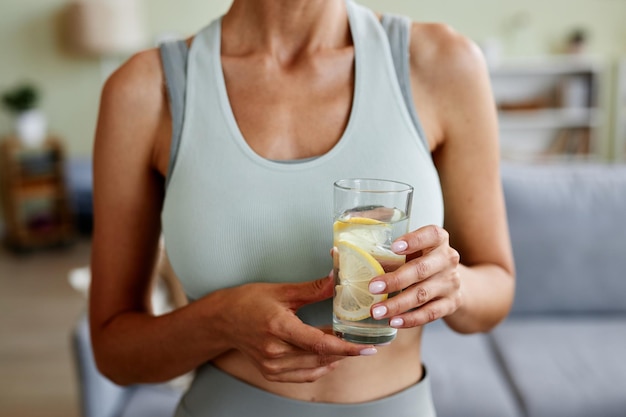 Zdjęcie sportowa kobieta trzyma szklankę wody