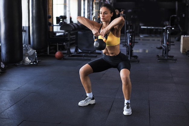 Sportowa kobieta z kettlebell w siłowni.