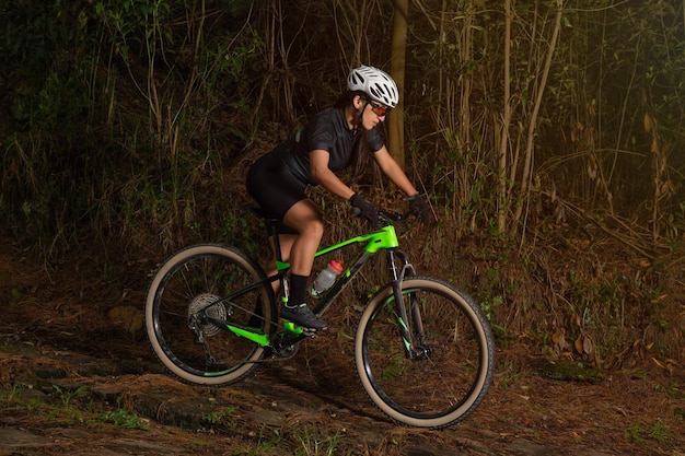 Sportowa latynoska kobieta jedzie na rowerze na górze