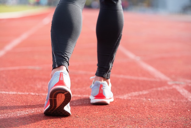 Sportowa osoba na bieżni przygotowuje się do rozpoczęcia biegu