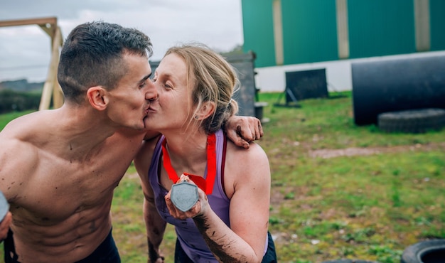 Zdjęcie sportowa para całuje się podczas ćwiczeń na lądzie