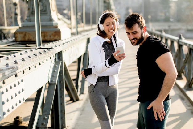 Sportowa para odpoczywa po joggingu w mieście