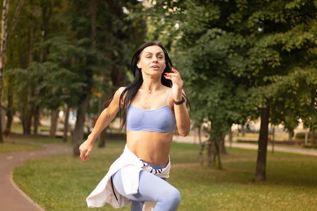Sportowa, szczęśliwa brunetka, ćwicząca na łące, z pełnej serii zdjęć