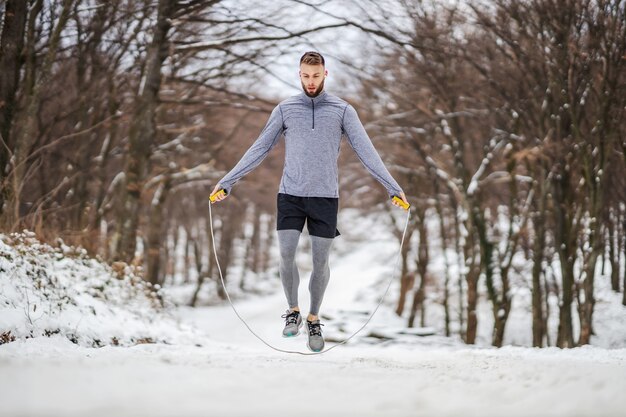 Sportowca w kształcie skakanka w przyrodzie na śniegu w zimie