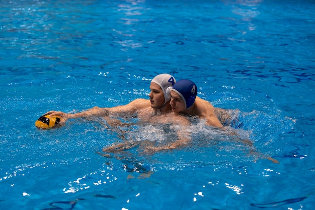 Zdjęcie sportowcy grający w piłkę wodną w basenie