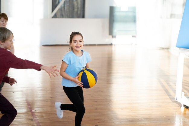 Sportowe dzieci grające razem w koszykówkę