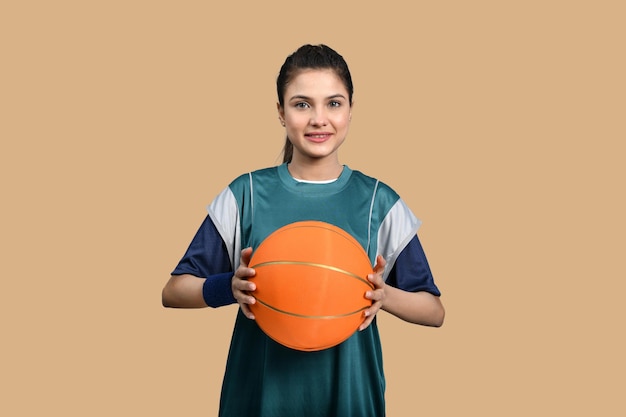 sportowe kobiety trzymające koszykówkę na pomarańczowym tle indyjski model pakistański