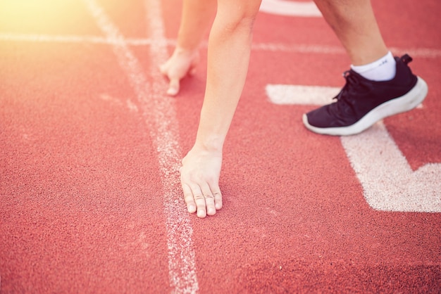 Sportowiec człowiek gotowy pozycji na linii startu do konkurowania