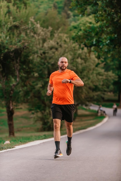 Sportowiec korzystający ze smartwatcha podczas biegania na łonie natury Zdrowy styl życia