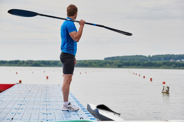 Sportowiec na molo z wiosłem