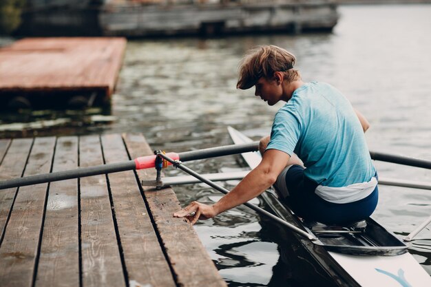 Sportowiec pojedynczy wioślarz wioślarz przygotowuje się do zawodów z łodzią