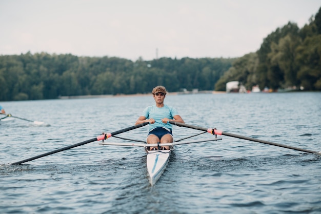 Sportowiec pojedynczy wioślarz wioślarz wiosłujący na łodzi