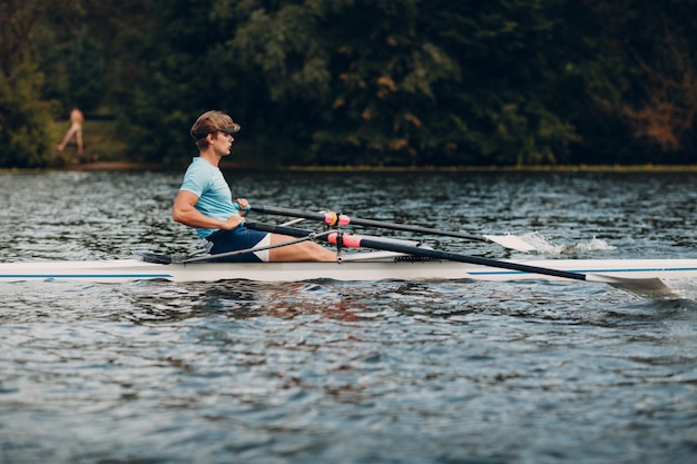 Sportowiec technika wioślarska wioślarza na łodzi. Ruch rozchlapywania wiosła wiosłowego