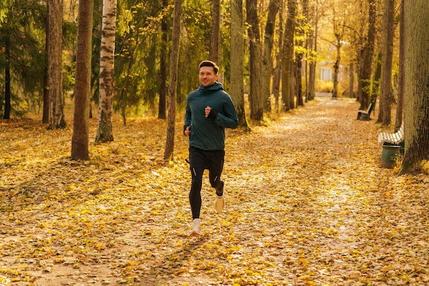 Sportowiec trenuje codziennie i w zimie Piękne jasne kolory jesieni Mężczyzna w ciepłych ubraniach sportowych