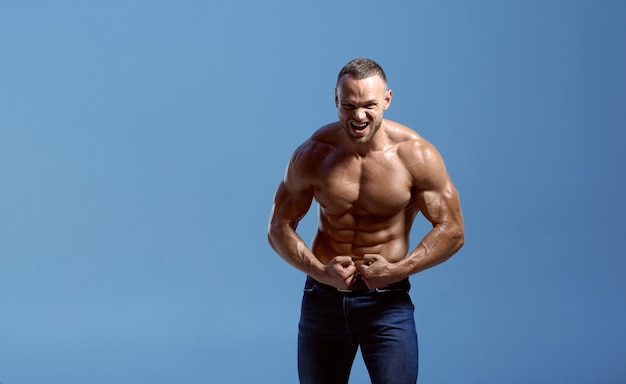 Sportowiec Z Muskularnym Ciałem Pokazuje Bicepsy W Studio