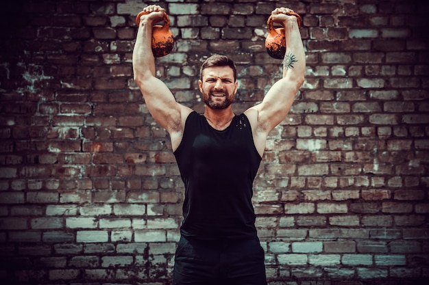 Sportowy mężczyzna pracujący z kettlebell. Siła i motywacja