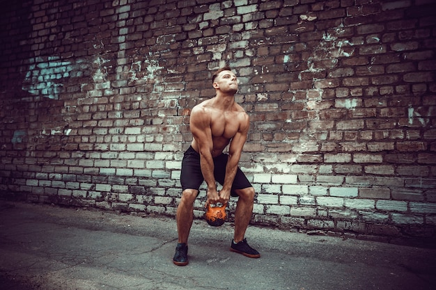 Sportowy mężczyzna pracujący z kettlebell. Siła i motywacja