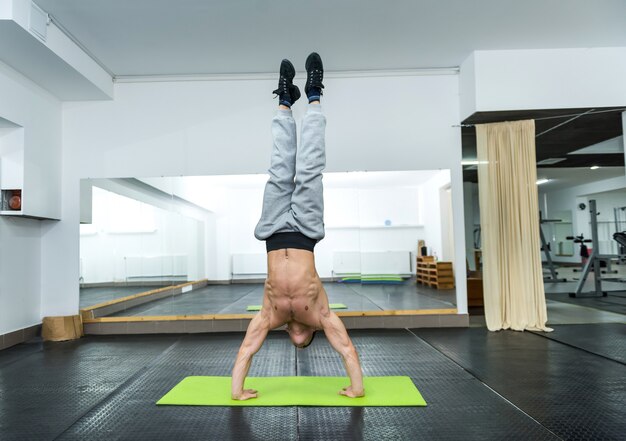 Sportowy Mężczyzna W Siłowni Stojący Na Rękach