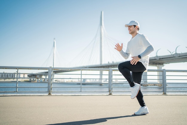 Sportowy, pewny siebie mężczyzna biega trenując na zewnątrz w wygodnej odzieży sportowej