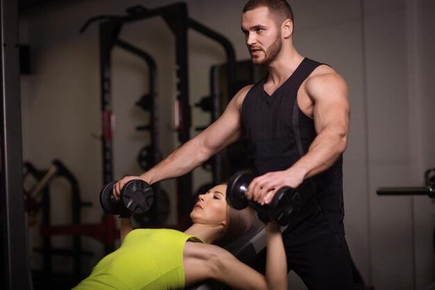 Sportowy seksowny mężczyzna i kobieta z wielkimi mięśniami brzucha w czarnej odzieży sportowej.