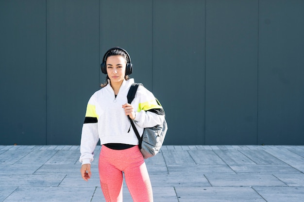Zdjęcie sportsmenka, słuchanie muzyki w słuchawkach na ulicy