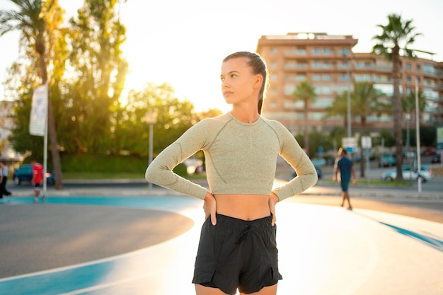 Sportsmenka stojąca na bieżni w letnim parku po porannym treningu odwracając wzrok Koncepcja aktywnego stylu życia