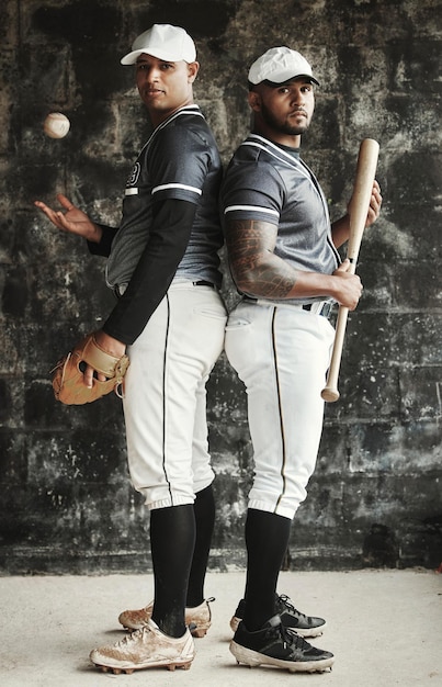 Zdjęcie sporty baseballowe i drużyna z mężczyzną sportowcem i zawodnikiem stojącym plecami do siebie w mundurze do treningu sportowa praca zespołowa i mundur z portretem przyjaciół gotowych do gry na tle ściany