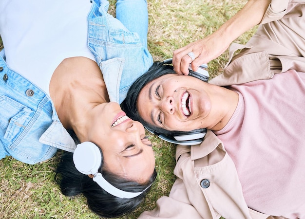Spotkaj się z przyjaciółmi i ciesz się kobietami i słuchawkami słuchającymi muzyki na świeżym powietrzu z podcastem i technologią Szczęście widok z góry radio i strumieniowe przesyłanie dźwięku w parku z ludźmi razem i dobre samopoczucie