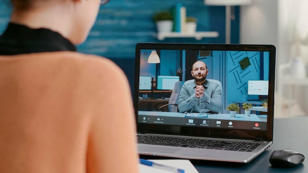 Zdjęcie spotkanie młodej kobiety z biznesmenem na komunikacji wideo w celu omówienia zadania szkolnego online. dorosły za pomocą laptopa do rozmowy z nauczycielem na zdalnej telekonferencji.