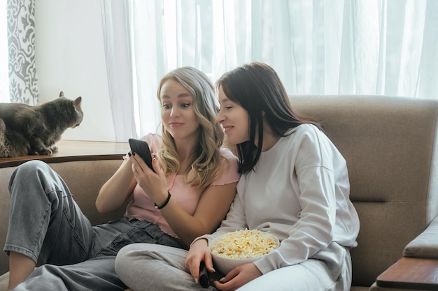 Spotkanie z dziewczynami w ciepłym domowym otoczeniu z popcornem i telefonem