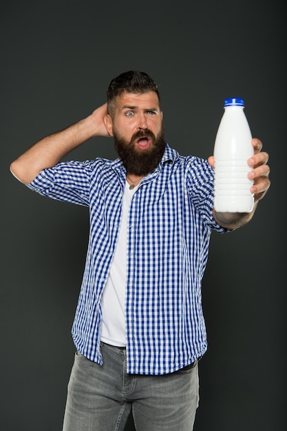 Spożywanie laktozy Zdrowe odżywianie Probiotyki jogurtowe i prebiotyki Brodaty mężczyzna trzymający białą butelkę z mlekiem Brutalny kaukaski hipster pić mleko Dieta z laktozą Opieka zdrowotna i dieta Produkty mleczne
