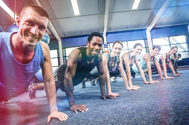 Zdjęcie sprawni ludzie ćwiczący na zajęciach fitness na siłowni