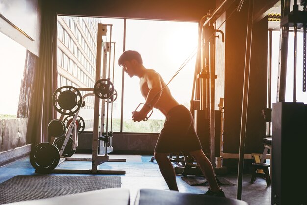 Sprawność fizyczna silny mężczyzna robi ciężkiemu ciężaru ćwiczeniu na maszynie w gym